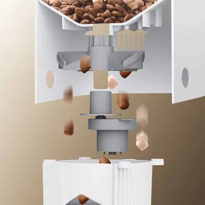 Querschnitt eines Futterautomaten, zeigt wie Trockenfutter durch das mechanische System in den Behälter fällt. Querschnitt eines Futterautomaten, zeigt wie Trockenfutter durch das mechanische System in den Behälter fällt.