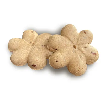 Hondenkoekjes in bloemvorm van bruin deeg met zichtbare rode stukjes.
