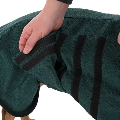 Hand showing the fastening of a green dog coat with Velcro.