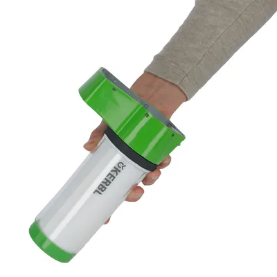 Hånd holder grønt og hvidt Kerbl-apparat, muligvis en foderautomat eller tilbehør til dyr.