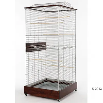 Голяма метална клетка за птици с дървена основа на колелца, няколко дървени кацалки и две метални купички за храна и вода, разположени отстрани.