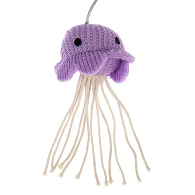 Juguete de ganchillo lila en forma de medusa con largos hilos blancos como tentáculos.