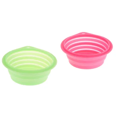 Deux gamelles rondes en silicone, une verte et une rose, avec rebords striés et trou pour suspension, visibles côte à côte.