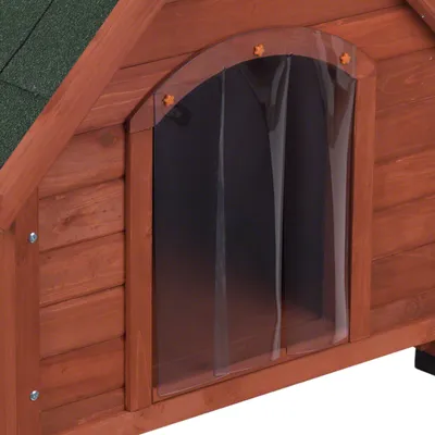 Porta in plastica trasparente applicata su cuccia in legno con tetto verde, pannelli verticali e viti visibili.