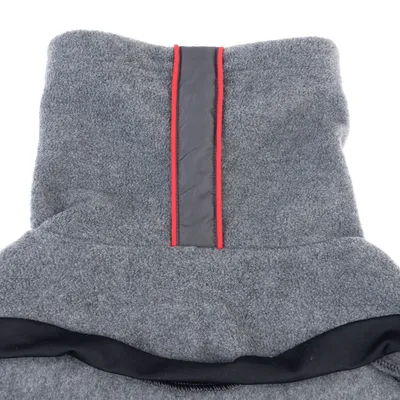 Grauer Fleece-Stoff mit schwarzem Rand und vertikalem Streifen in Grau mit rotem Akzent. Detailansicht des Materials.
