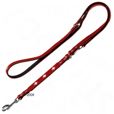 Hundkoppel i rött läder med metallspännen och vita korsformade dekorationer, justerbar längd synlig på bilden.