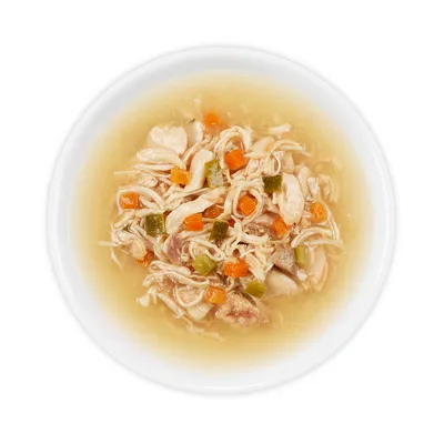 Close-up of a bowl with chicken meat, carrots and courgettes in broth. Visible ingredients: shredded meat and vegetables.