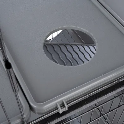 Placă din plastic gri cu decupaj rotund și structură ondulată, fixată pe o rețea metalică.