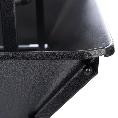 Detailaufnahme einer schwarzen Metallwanne mit strukturierter Oberfläche und Befestigungsschraube.