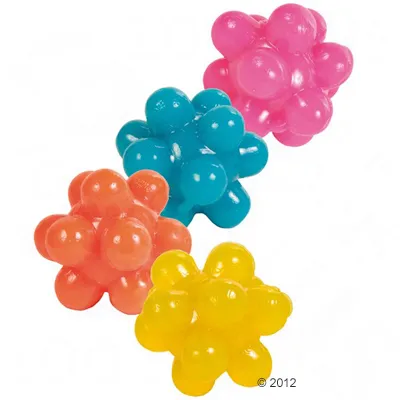 Fyra klotformade hundleksaker i plast med utstickande knoppar, i färgerna rosa, blå, orange och gul. Ingen synlig text eller varumärke.