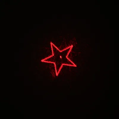 Red star as laser projection on black background.