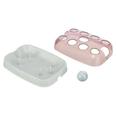 Interactief voerspel voor huisdieren van kunststof, bestaande uit een witte bak met pinnen, een roze deksel met ronde openingen en een kleine doorzichtige bal.