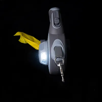 Graue Hundeleine mit integriertem LED-Licht, gelbem Beutelspender und Metallkarabinerhaken.