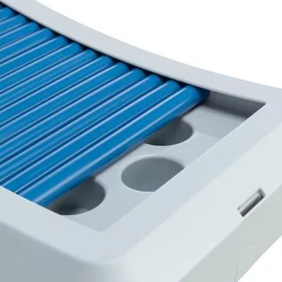Närbild av en vit plastprodukt med blå räfflor och runda fördjupningar, eventuellt del av en katt­leksak eller en matstation.