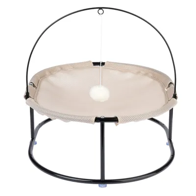 Rund beige nätbädd med svart metallram och hängande vit plyschboll på ett snöre.