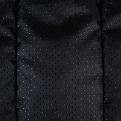 Close-up of a black, dotted fabric material with padded texture.