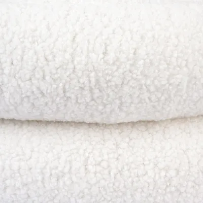 Close-up of white, fluffy fabric with wool-like texture.