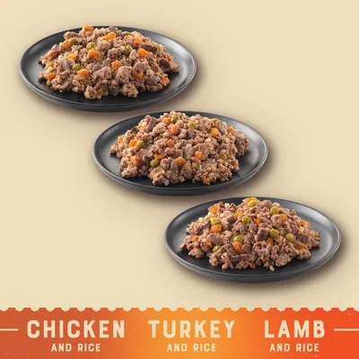 Three plates of food labelled as chicken and rice, turkey and rice, and lamb and rice, each showing a mix with visible vegetables.