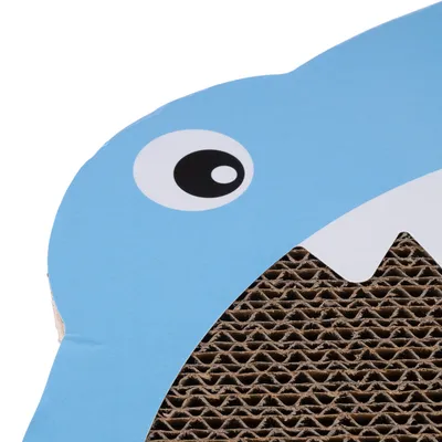Surface en carton ondulé avec motif bleu représentant un œil et des dents blanches, partie d’un griffoir pour chat visible sur l’image.