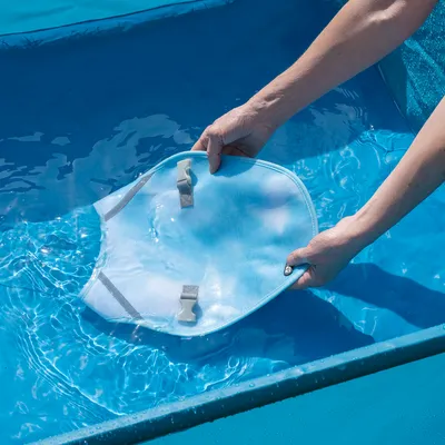 Person taucht ein blaues Netz mit Clips in Wasser, möglicherweise zur Reinigung oder Verwendung im Pool.