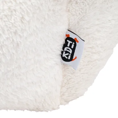 Close-up of a white, fluffy material with Tiaki logo on a sewn-on label.