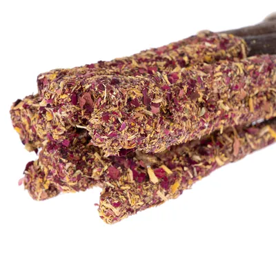 Közelkép több szárított virágokkal és gyógynövényekkel borított stickről, alkalmas snacknek vagy rágókának.