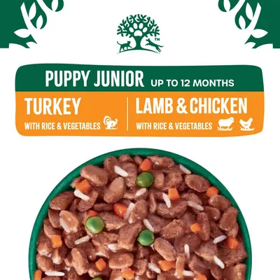 Puppy Junior food for up to 12 months, available in turkey with rice and vegetables or lamb and chicken with rice and vegetables. Image shows chunks with peas, carrots, and rice.