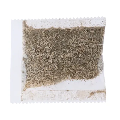 Transparenter Beutel mit getrockneten Kräutern und Holzstückchen, sichtbar durch die Verpackung.