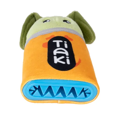 Tiaki hundleksak med orange tyg, gröna öron och blå plastdel med taggar. Lämplig för interaktiv lek.