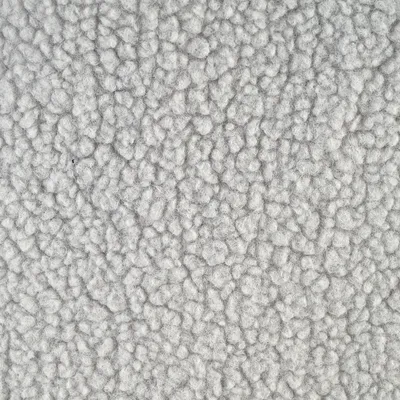 Gros plan sur une surface en tissu polaire gris, texture bouclée visible. Matériau utilisé pour accessoires ou couchages pour animaux.