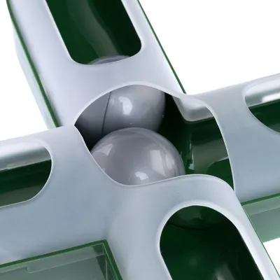 Vista detallada de un juguete verde con bolas grises en diseño en forma de cruz, adecuado para juego interactivo.