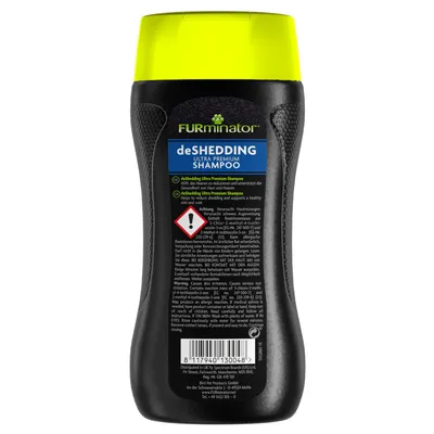 FURminator deSHEDDING Ultra Premium Shampoo flaske med advarselstrekant og tekst på engelsk og tysk om produktets anvendelse og ingredienser. Stregkode synlig nederst.
