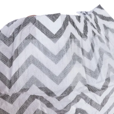 Nahaufnahme eines weißen Materials mit grauem Zickzack-Muster, möglicherweise Textil oder Papier.