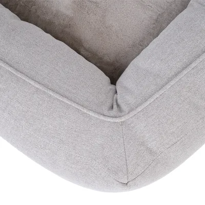 Close-up of a grey pet bed with soft padding and fabric cover.