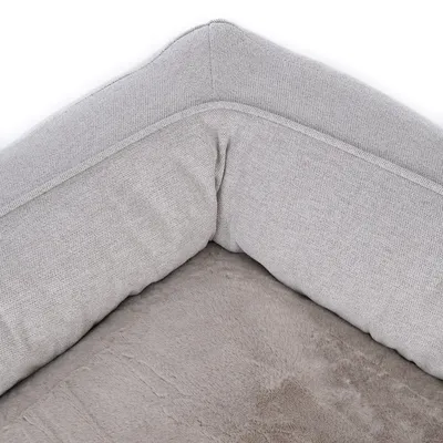 Close-up of a grey pet bed with soft padding and fabric cover.