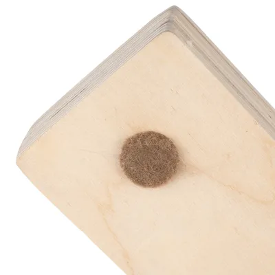 Hoek van een houten plank met viltglijder ter bescherming van vloeren.