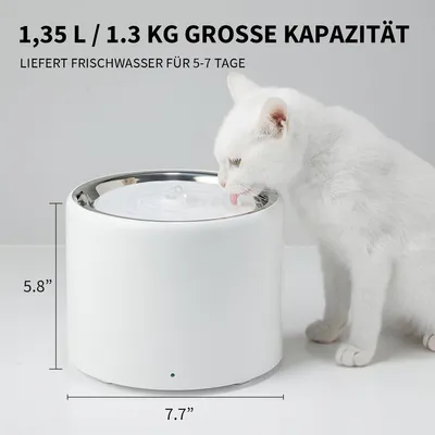 Trinkbrunnen mit 1,35 L Kapazität, liefert Frischwasser für 5-7 Tage. Masse: Höhe 5,8 Zoll, Durchmesser 7,7 Zoll. Weisser Trinkbrunnen mit Katze beim Trinken.
