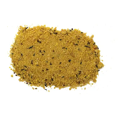 Yellow, granular bird food with small black seeds and various particles.