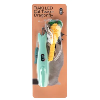 Tiaki LED Cat Teaser Dragonfly, παιχνίδι με πράσινη λαβή και κίτρινη λιβελούλα, συσκευασία με λεπτομέρειες προϊόντος και γάτα στο φόντο.