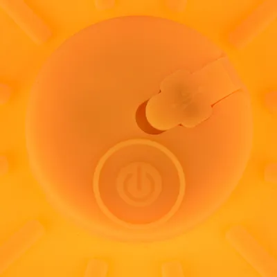 Nærbillede af et orange produkt med USB-port og tænd/sluk-knap-symbol.