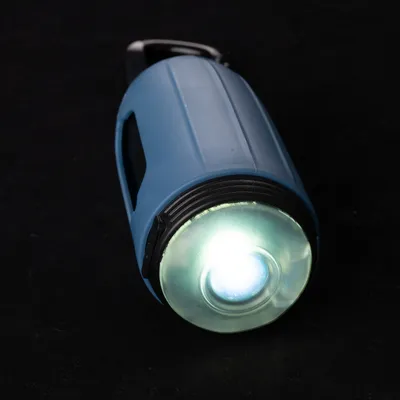 Blaue Taschenlampe mit leuchtender LED-Linse und schwarzem Griff.