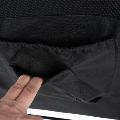 Nahaufnahme einer schwarzen Stofftasche mit elastischem Rand, in die eine Hand greift. Tasche ist Teil eines Produkts.