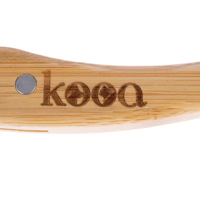 kooa. Premium-Pflegemarke für Haustiere, graviert auf einem Holzgriff mit Metallakzent.