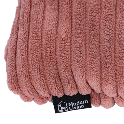 Gros plan sur un coussin en tissu à reliefs, étiquette visible avec la marque Modern Living.