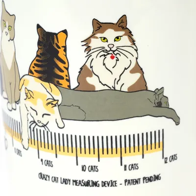 Illustration de chats avec une échelle graduée marquée '9 cats' à '12 cats' et texte en anglais : 'Crazy Cat Lady Measuring Device – Patent Pending'.