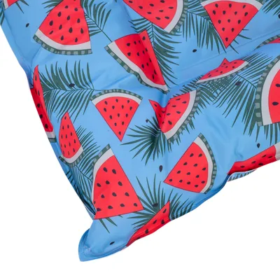 Cojín azul con estampado de sandía y hojas de palma.