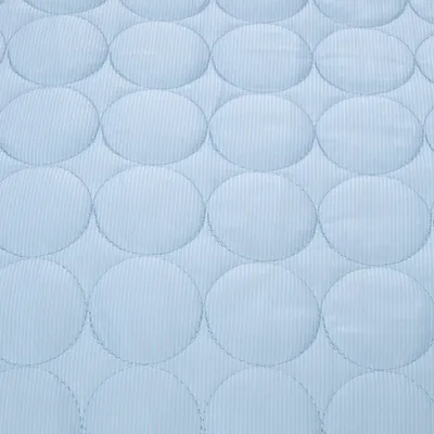 Jasnoniebieska tkanina z okrągłym wzorem pikowania, odpowiednia na poduszki lub legowiska dla zwierząt.
