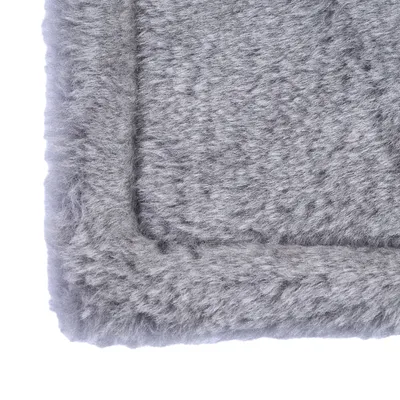 Grey, fluffy surface of a rectangular pet bed, close-up of the soft texture.