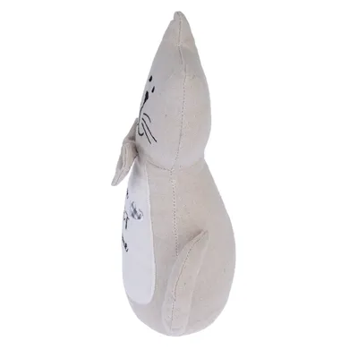 Beiges Stoffspielzeug in Katzenform mit aufgesticktem Gesicht und appliziertem Herzmotiv. Seitenansicht des Spielzeugs.