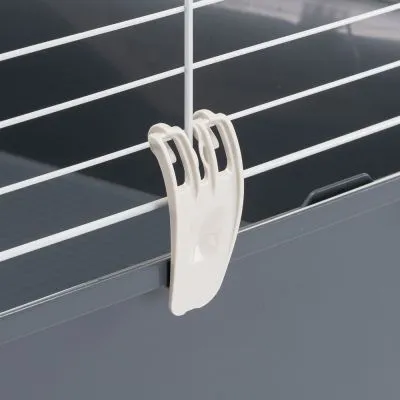 Gancio in plastica bianca fissato su una gabbia con sbarre metalliche bianche e base grigia, dettaglio del sistema di chiusura o aggancio visibile.